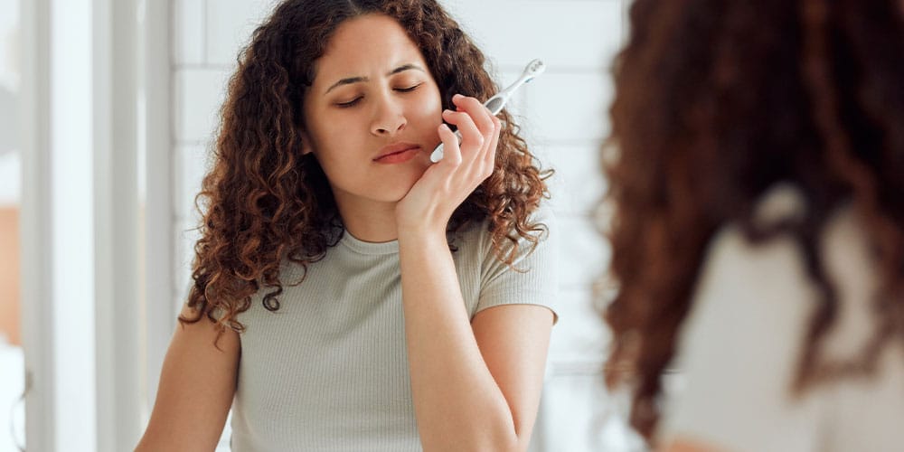 woman experiencing gum disease symptoms in Beverly Hills