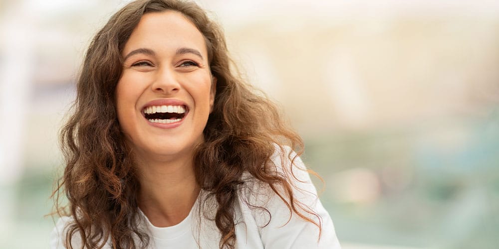 happy woman after treating her gum health after stress in Los Angeles, CA