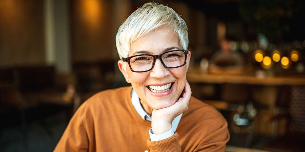 older woman smiling after getting dentures in Los Angeles, CA